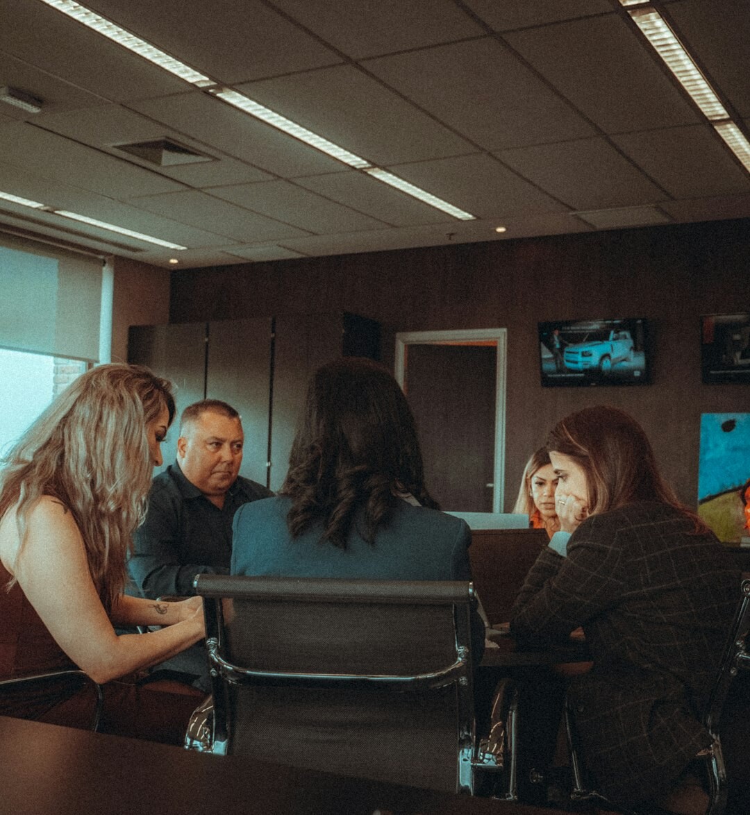 Diverse team of Belgian journalists discussing the day's business news in a newsroom meeting