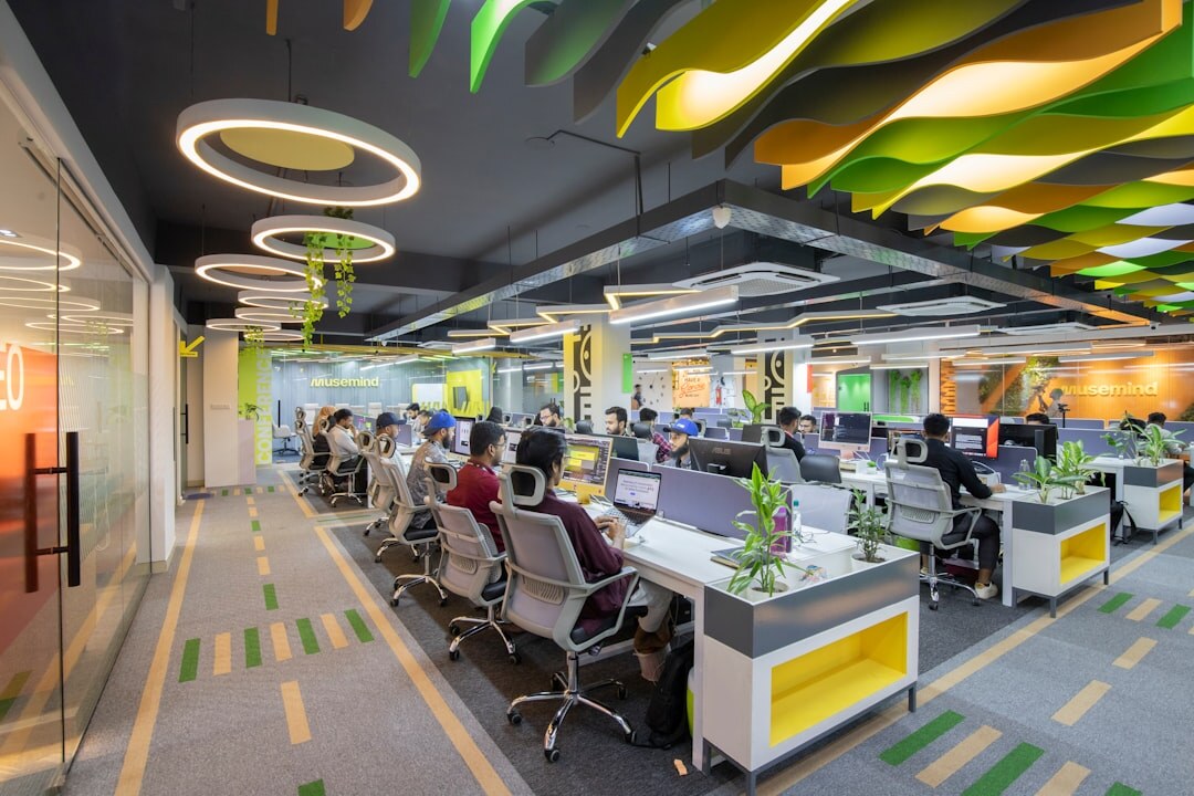 Modern open-plan newsroom office with desks, monitors and editorial boards