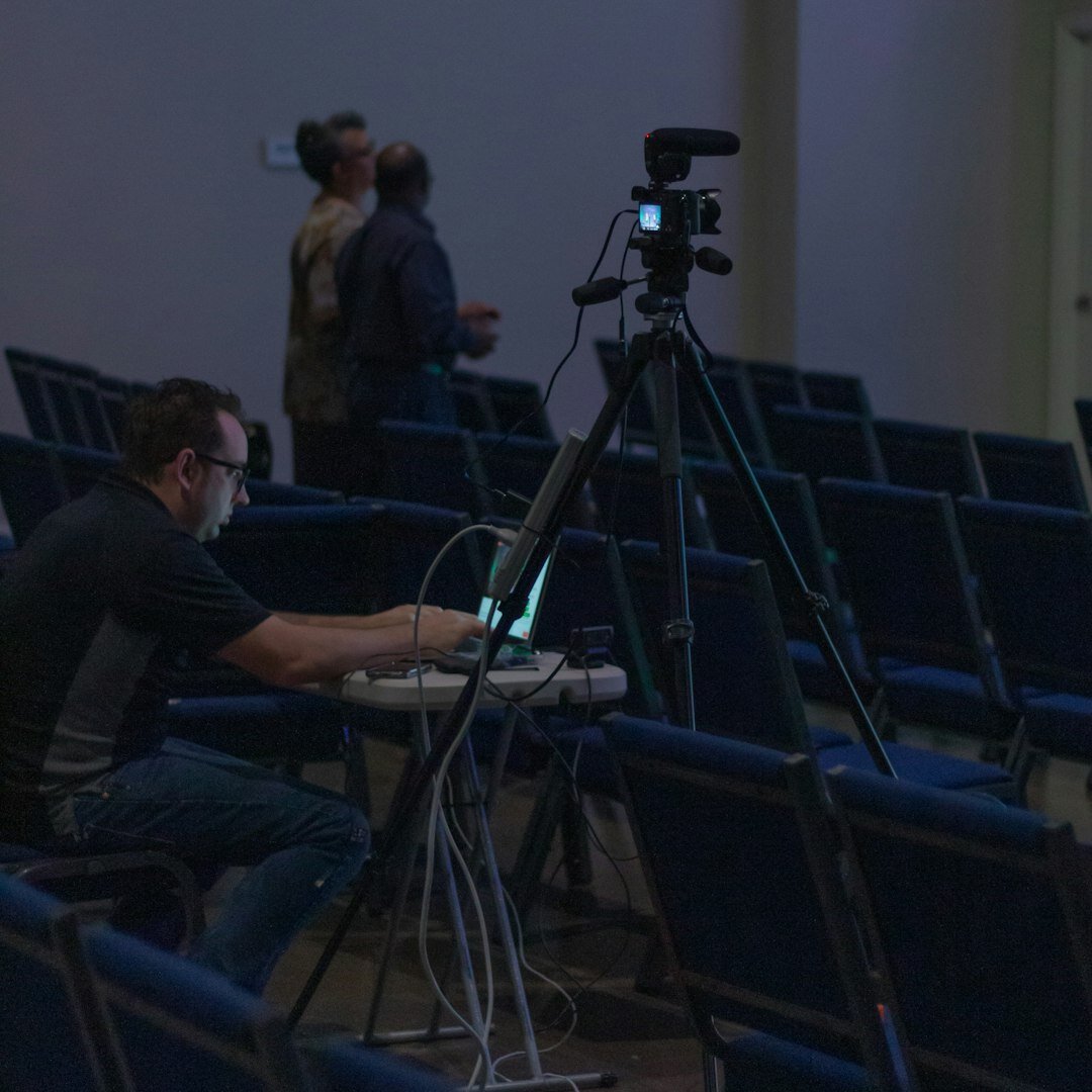 Belgian business journalist holding a professional camera during a press assignment
